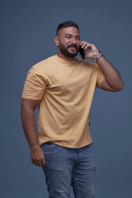 Smiling Saudi Man Talking on Smartphone in Blue Studio