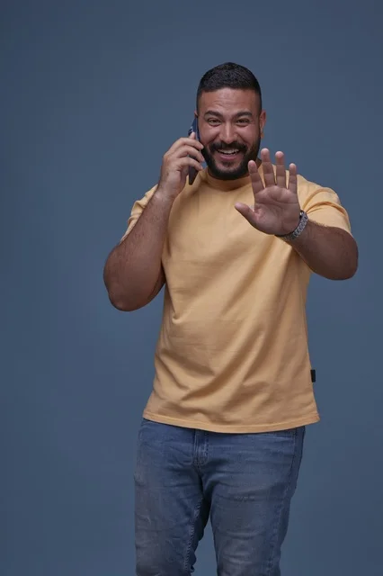 Smiling Saudi Man Talking on Smartphone in Casual Wear