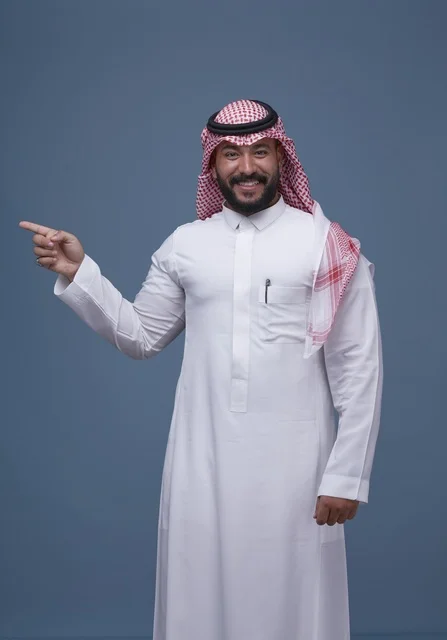 رجل سعودي بالثوب التقليدي يشير بيده في الاستوديو