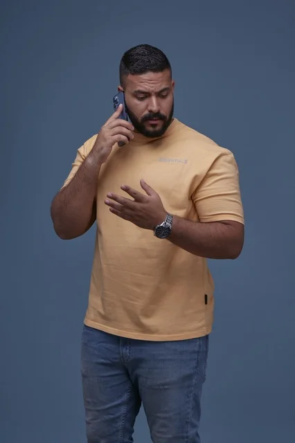 Saudi Man Talking on Smartphone in Casual Yellow T-shirt