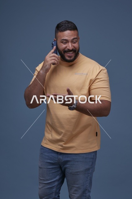 رجل سعودي مبتسم يتحدث عبر الهاتف في الاستوديو