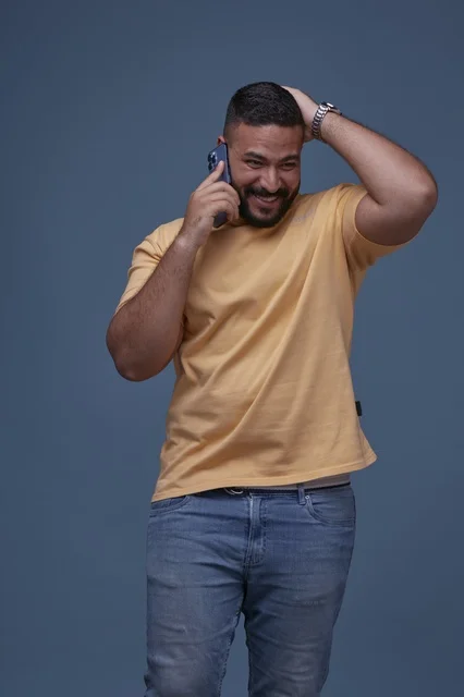 Smiling Saudi Man Talking on Smartphone in Casual Wear