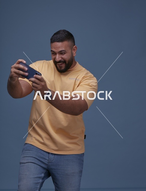 شاب سعودي يلعب ألعاب الجوال في الاستوديو