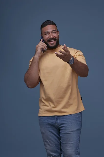 Smiling Saudi Man in Casual Wear Talking on Mobile Phone