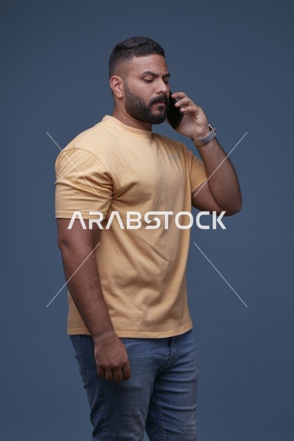 رجل عربي يتحدث عبر الهاتف الجوال بخلفية زرقاء