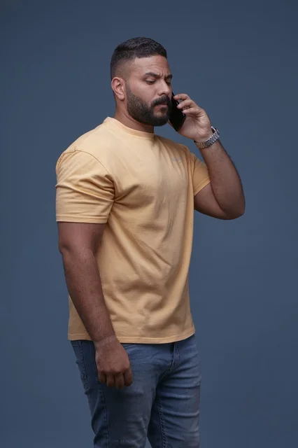 رجل عربي يتحدث عبر الهاتف الجوال بخلفية زرقاء