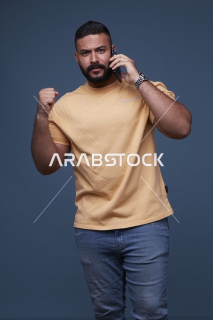 رجل سعودي يتحدث بالهاتف مع رفع قبضة اليد