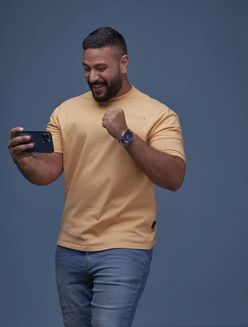 Excited Saudi Man Celebrating Success on Smartphone