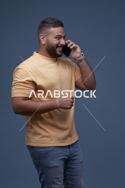 رجل سعودي يتحدث بالهاتف بملابس كاجوال عصرية