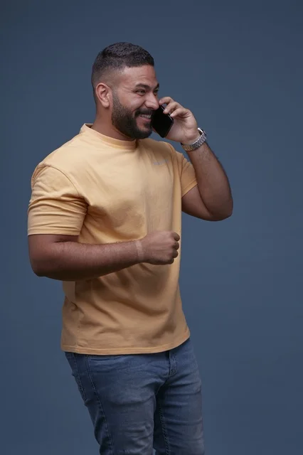 رجل سعودي يتحدث بالهاتف بملابس كاجوال عصرية