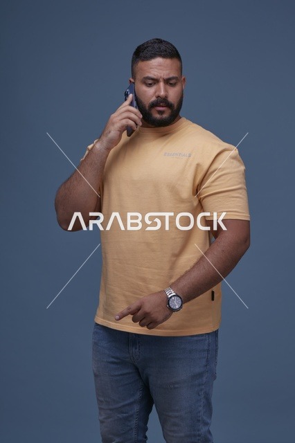 رجل سعودي يتحدث بالهاتف بملابس كاجوال
