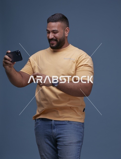 شاب سعودي يستخدم الهاتف الذكي بخلفية زرقاء