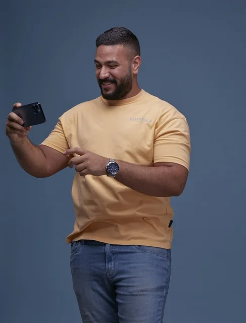 Saudi Man Using Smartphone on Blue Background