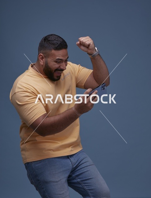 شاب سعودي يحتفل بالفوز في لعبة هاتف ذكي