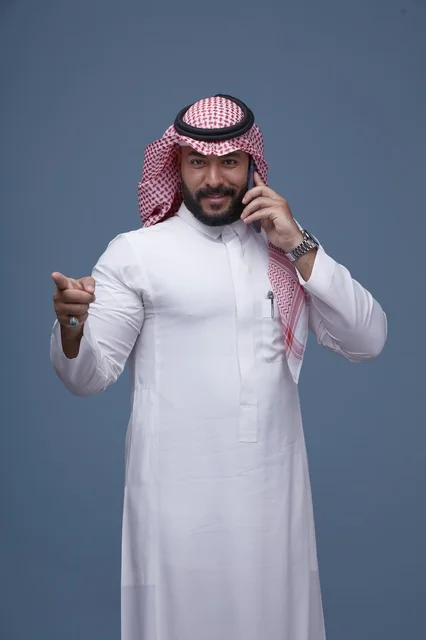 Smiling Saudi Man Talking on Smartphone and Pointing
