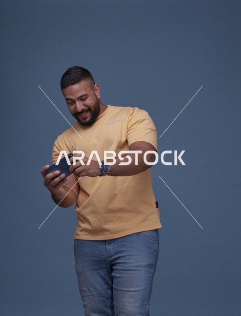 شاب سعودي يلعب على الهاتف الذكي في الاستوديو