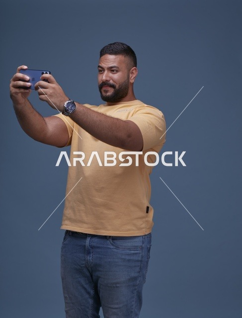 شاب سعودي يلعب بالهاتف الذكي في الاستوديو
