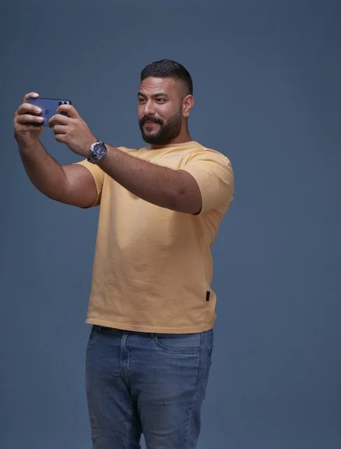 Saudi Man Playing Mobile Game on Smartphone in Studio