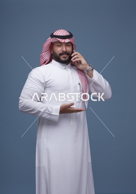 رجل سعودي يتحدث عبر الجوال بالزي التقليدي