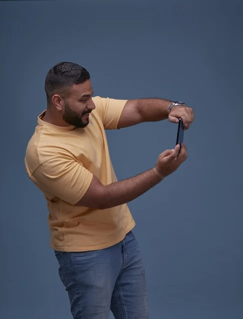 شاب سعودي يلعب ألعاب الفيديو على الهاتف الذكي