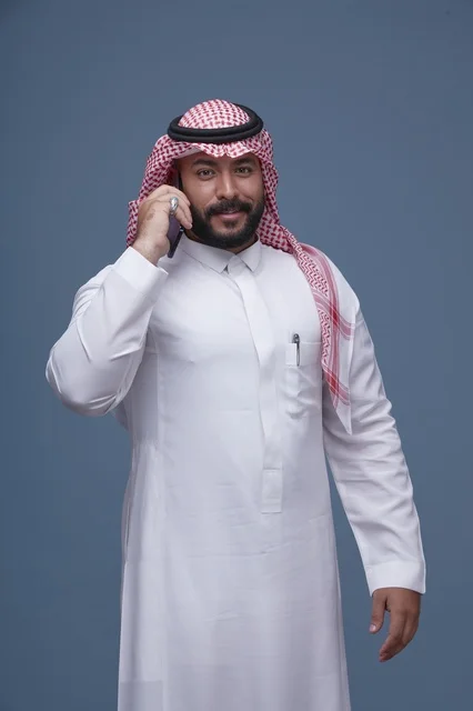 Saudi Man in Traditional Dress Talking on Smartphone