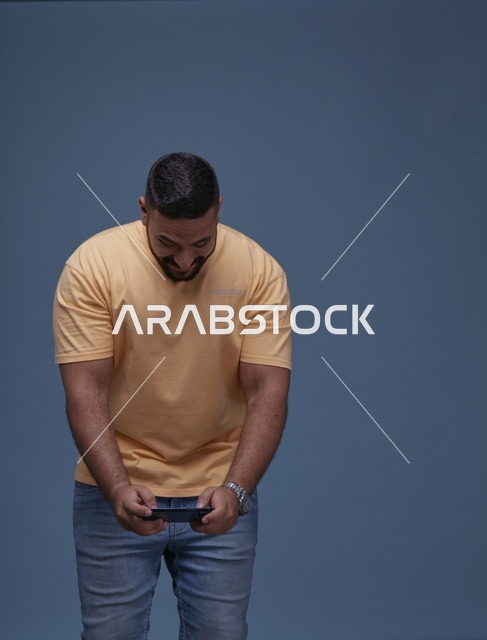 شاب سعودي يلعب ألعاب الجوال على هاتف ذكي