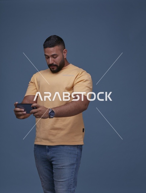 شاب سعودي يلعب ألعاب الفيديو على الهاتف الذكي