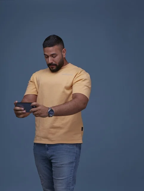 Saudi Man Playing Video Game on Smartphone in Studio