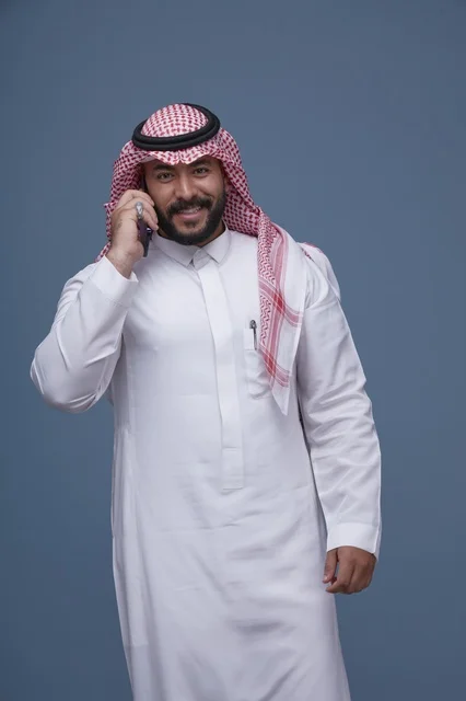 Smiling Saudi Man Talking on Smartphone Studio Portrait