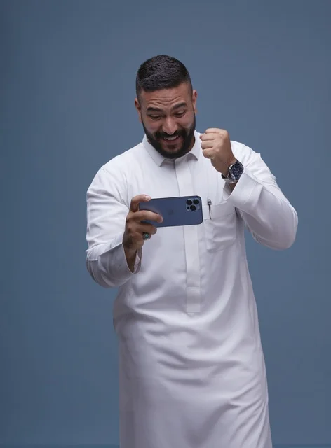 Saudi Man Playing Mobile Game on Smartphone