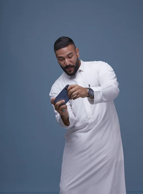 Saudi Man Using Smartphone for Mobile Gaming in Studio