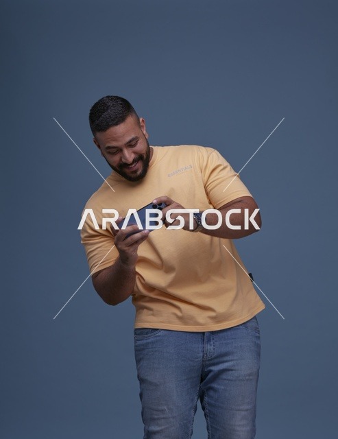 شاب سعودي يلعب ألعاب الجوال بالهاتف الذكي بالاستوديو