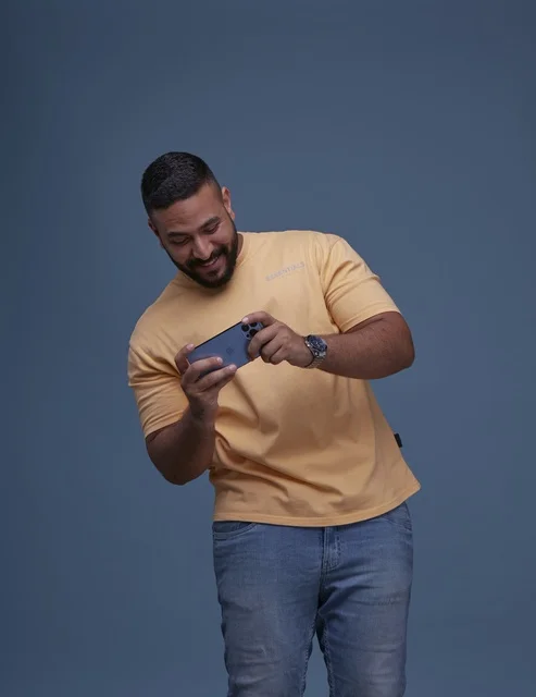 شاب سعودي يلعب ألعاب الجوال بالهاتف الذكي بالاستوديو