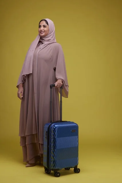 Saudi Woman with Blue Suitcase on Yellow Background
