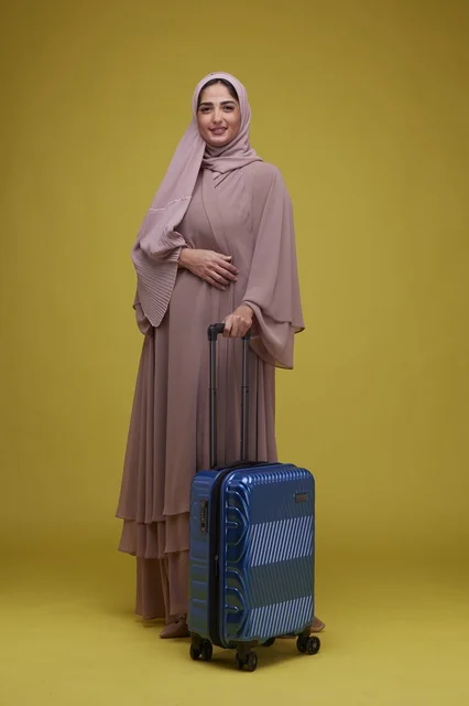 Saudi Woman with Blue Suitcase on Yellow Background