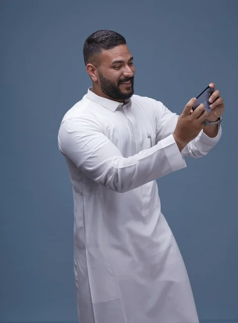 Saudi Man Using Smartphone for Mobile Gaming Studio