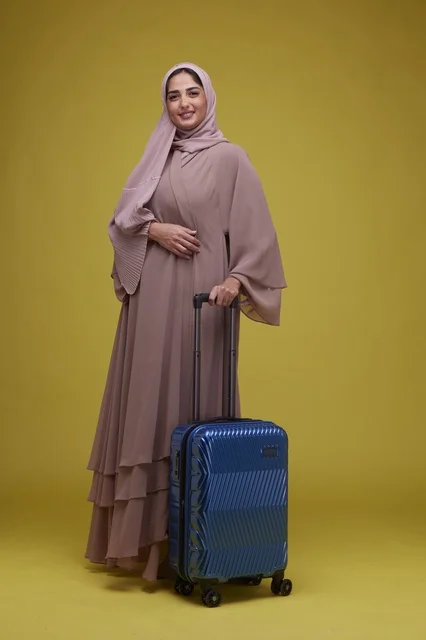 Saudi Woman with Blue Suitcase on Yellow Background