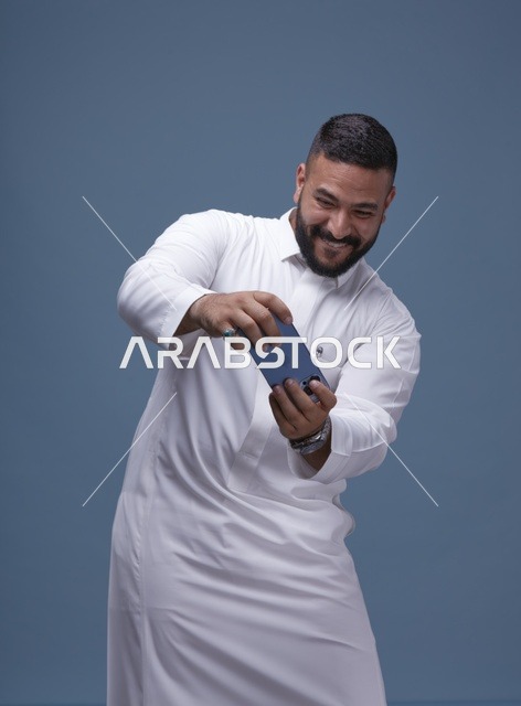 رجل سعودي يلعب ألعاب الجوال على الهاتف الذكي