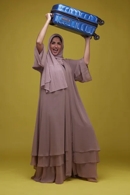 امرأة سعودية مستعدة للسفر مع حقيبة سفر