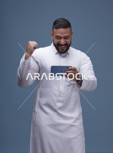 رجل سعودي يحتفل بالفوز في ألعاب الجوال الذكية