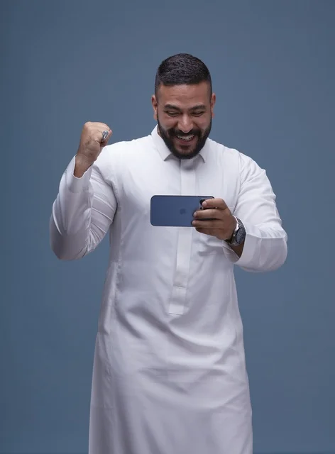 رجل سعودي يحتفل بالفوز في ألعاب الجوال الذكية