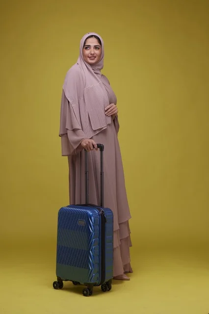 Saudi Woman with Blue Suitcase on Yellow Background