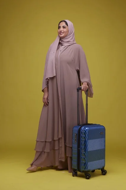 Saudi Woman with Blue Suitcase on Yellow Background
