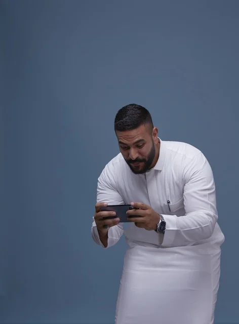 Saudi Man Playing Mobile Games on Smartphone