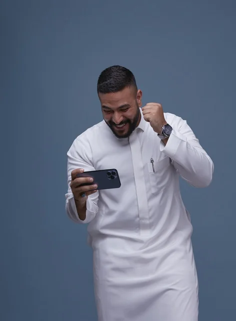 Saudi Man Using Smartphone for Mobile Gaming in Studio