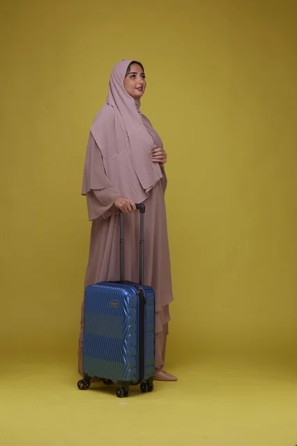 Saudi Woman Traveler with Blue Suitcase in Studio
