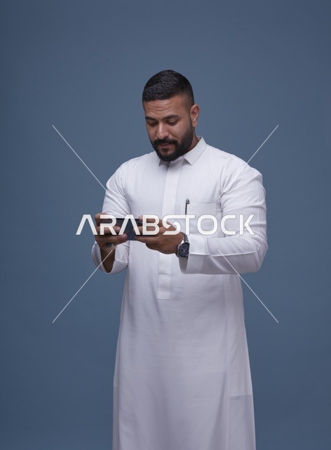 رجل سعودي يستخدم الهاتف الذكي للألعاب في استوديو