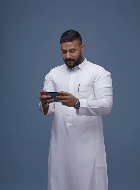 رجل سعودي يستخدم الهاتف الذكي للألعاب في استوديو