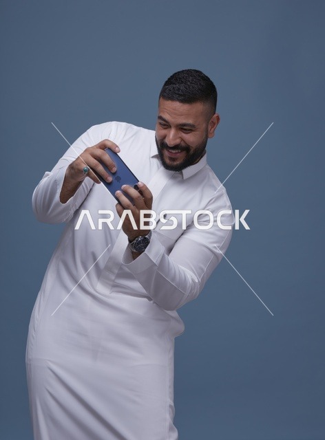 رجل سعودي يلعب ألعاب المحمولة على الهاتف الذكي
