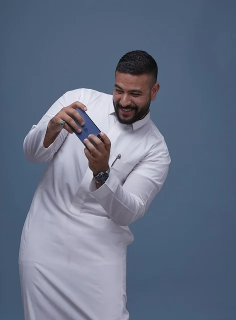 Saudi Man Playing Mobile Game on Smartphone